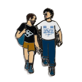 The Couple enamel pin—a couple walking down the street and talking, as illustrated by Jiaqi Wang.