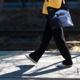 Woman walking along the High Line, holding the Dinosaur Tote.