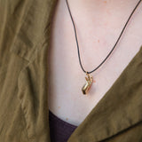 Abhaya mudra pendant on a person's neck.