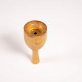 Robin bird call made from wood and metal shown balanced on the mouthpiece.