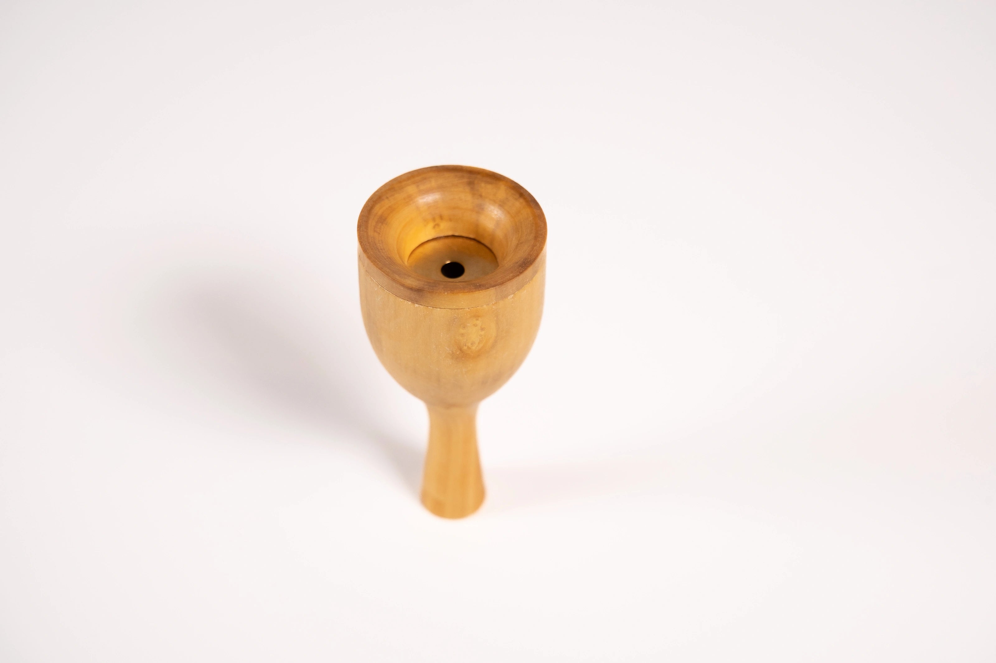Robin bird call made from wood and metal shown balanced on the mouthpiece.