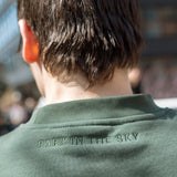 Close-up of "Park in the sky" neck embroidery detail. Person wears Big Icon Crewneck in Ivy while on the High Line.