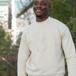 Man wearing Big Icon Crewneck in River Birch with monochromatic High Line icon embroidered on the front standing on the High Line.