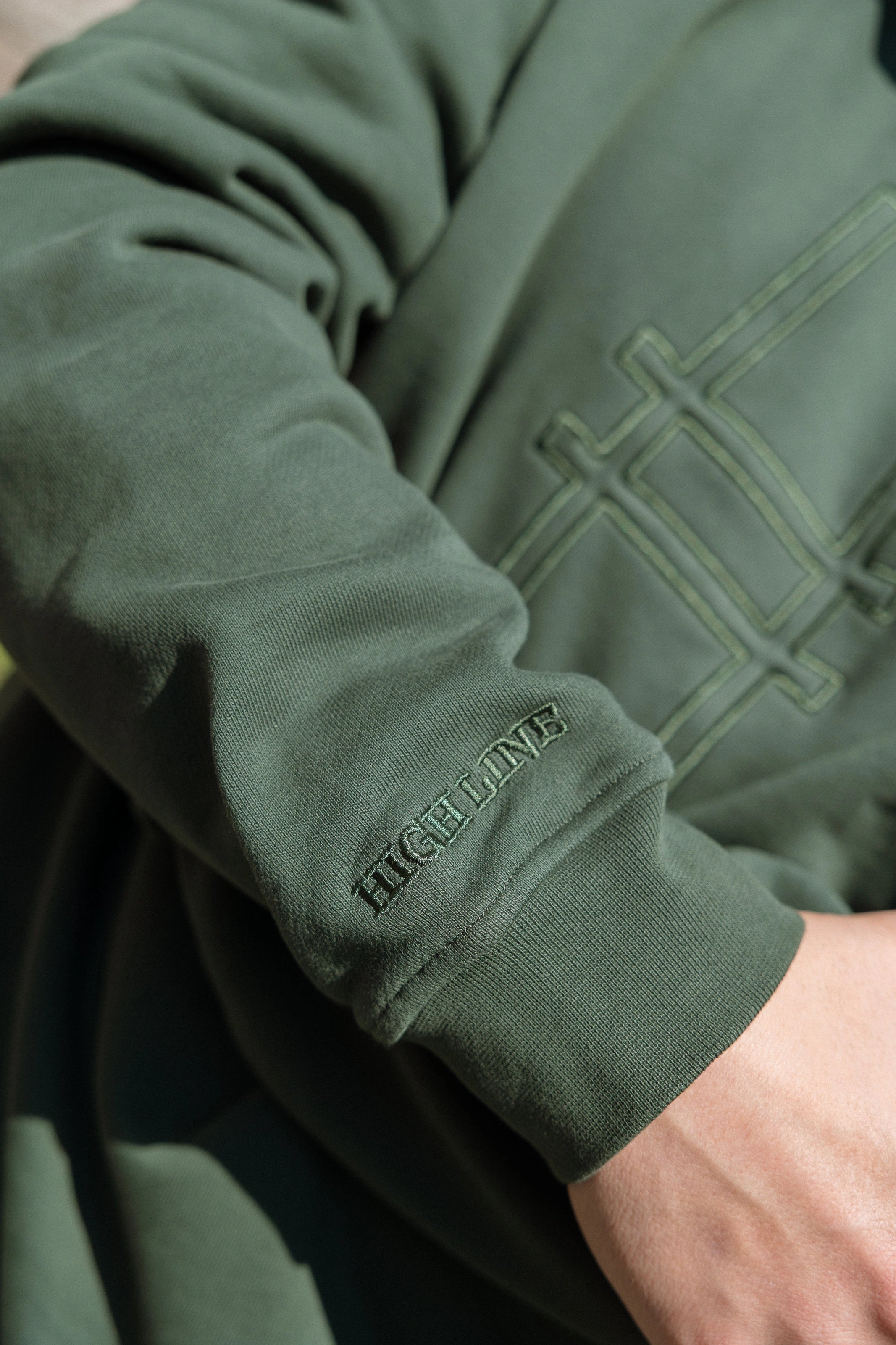 Big Icon Crewneck in Ivy with monochromatic embroidery details. Front features big High Line icon and High Line wordmark on sleeve. Close-up on embroidery details.