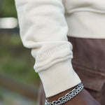 Closeup of the Big Icon Crewneck in River Birch with monochromatic High Line wordmark embroidered on the sleeve.