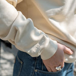 Closeup of the Big Icon Crewneck in River Birch with monochromatic High Line wordmark embroidered on the sleeve.