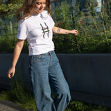Woman walking on the Pershing Square Beams on the High Line and wearing the Big Icon Tee in white.