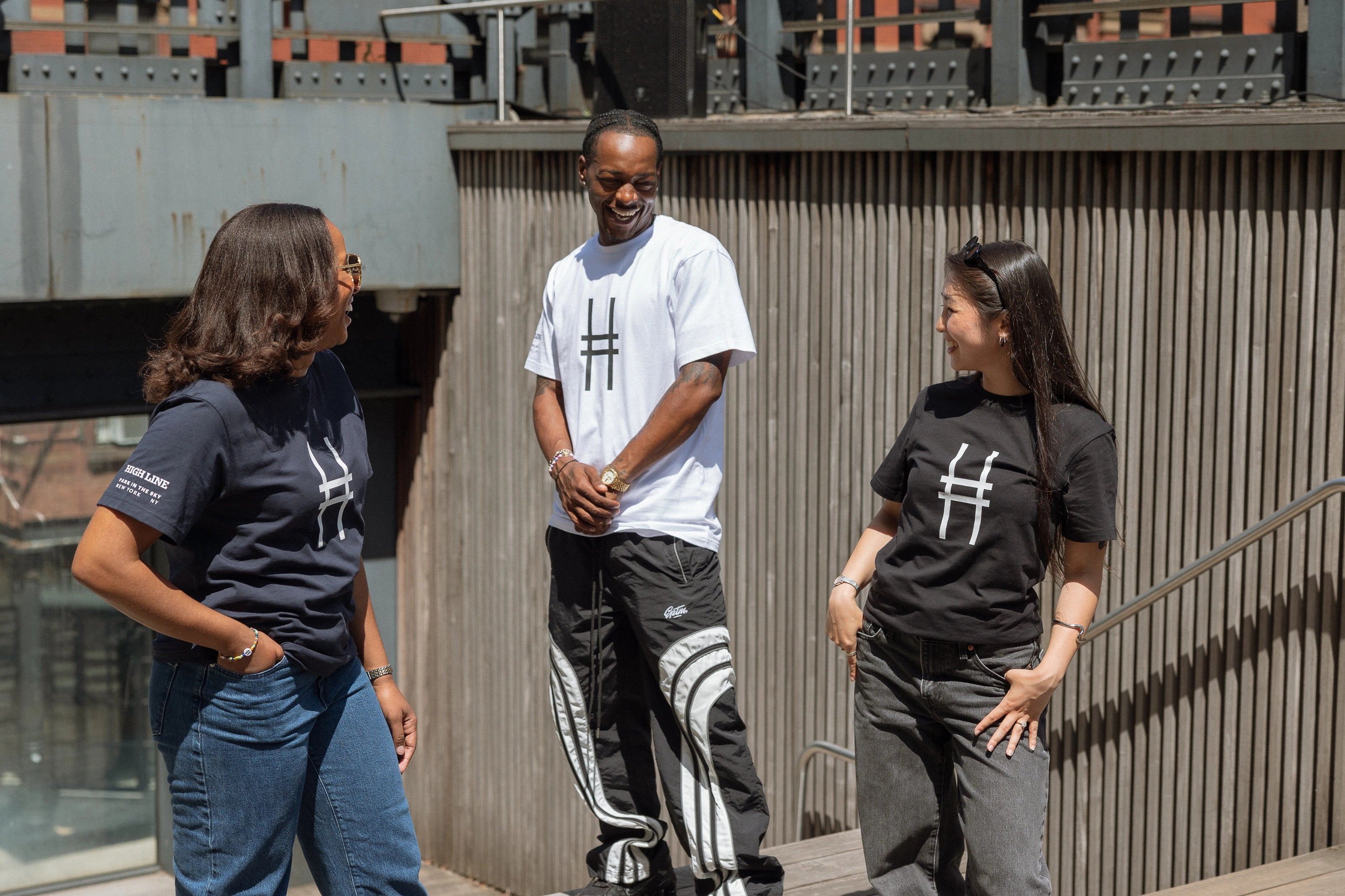 Three people, all in Big Icon Tees, laughing with each other.
