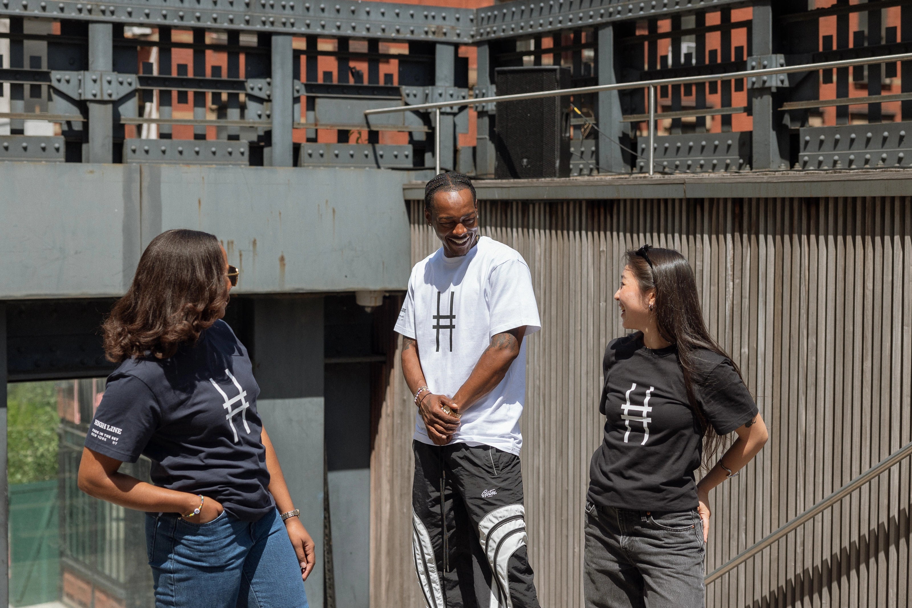Three people, all in Big Icon Tees, laughing with each other.