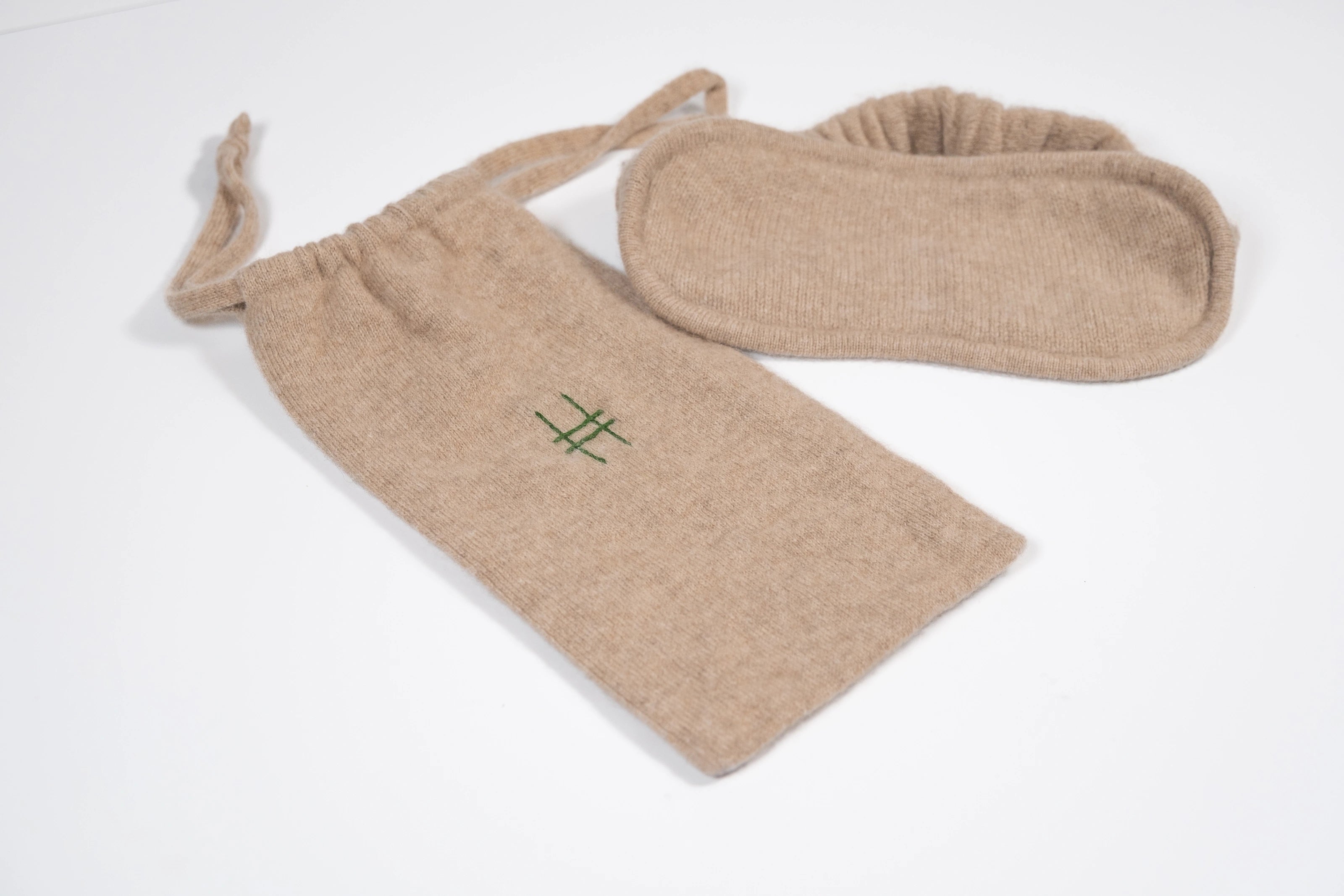 The Lingua Franca x High Line 100% Cashmere Eye Mask with travel case. This oatmeal-colored eye mask comes with a 100% cashmere travel bag embroidered with the High Line icon in green.