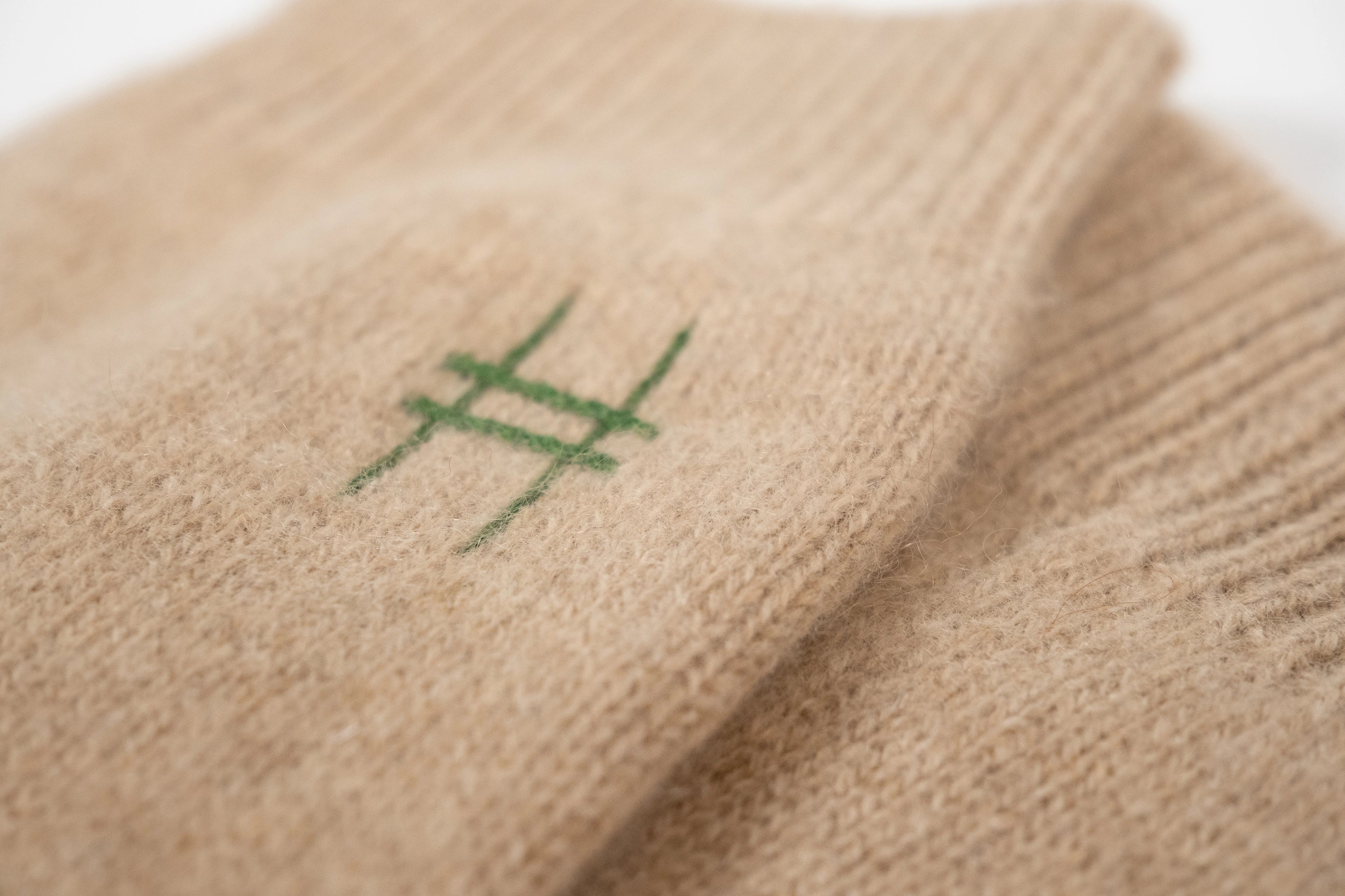Closeup of Lingua Franca x High Line 100% Cashmere Socks, detailing the High Line icon.