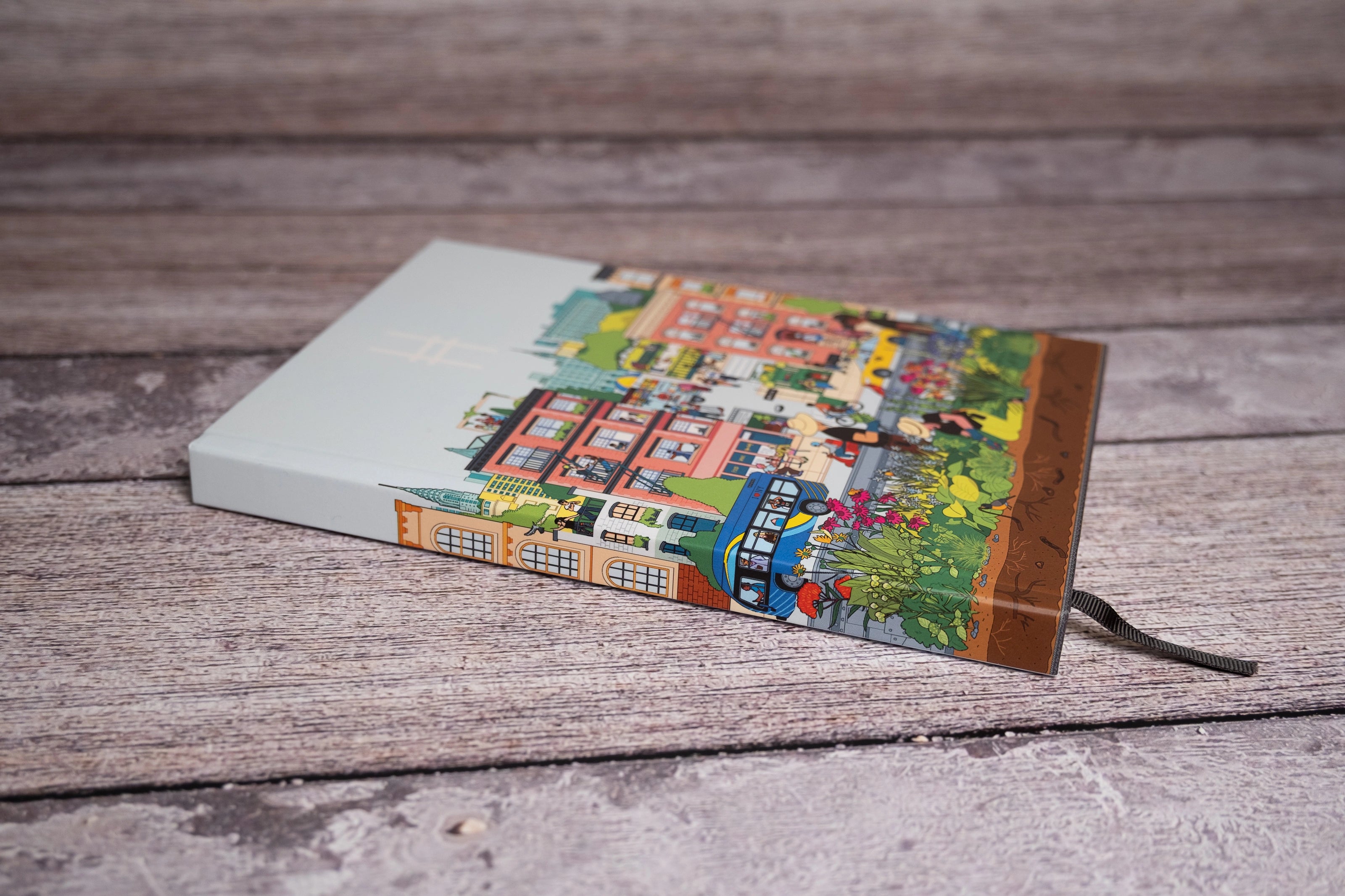 Community in the Sky Notebook featuring Jiaqi Wang's Nature in the City illustration and the High Line icon, shown laying against a bench.