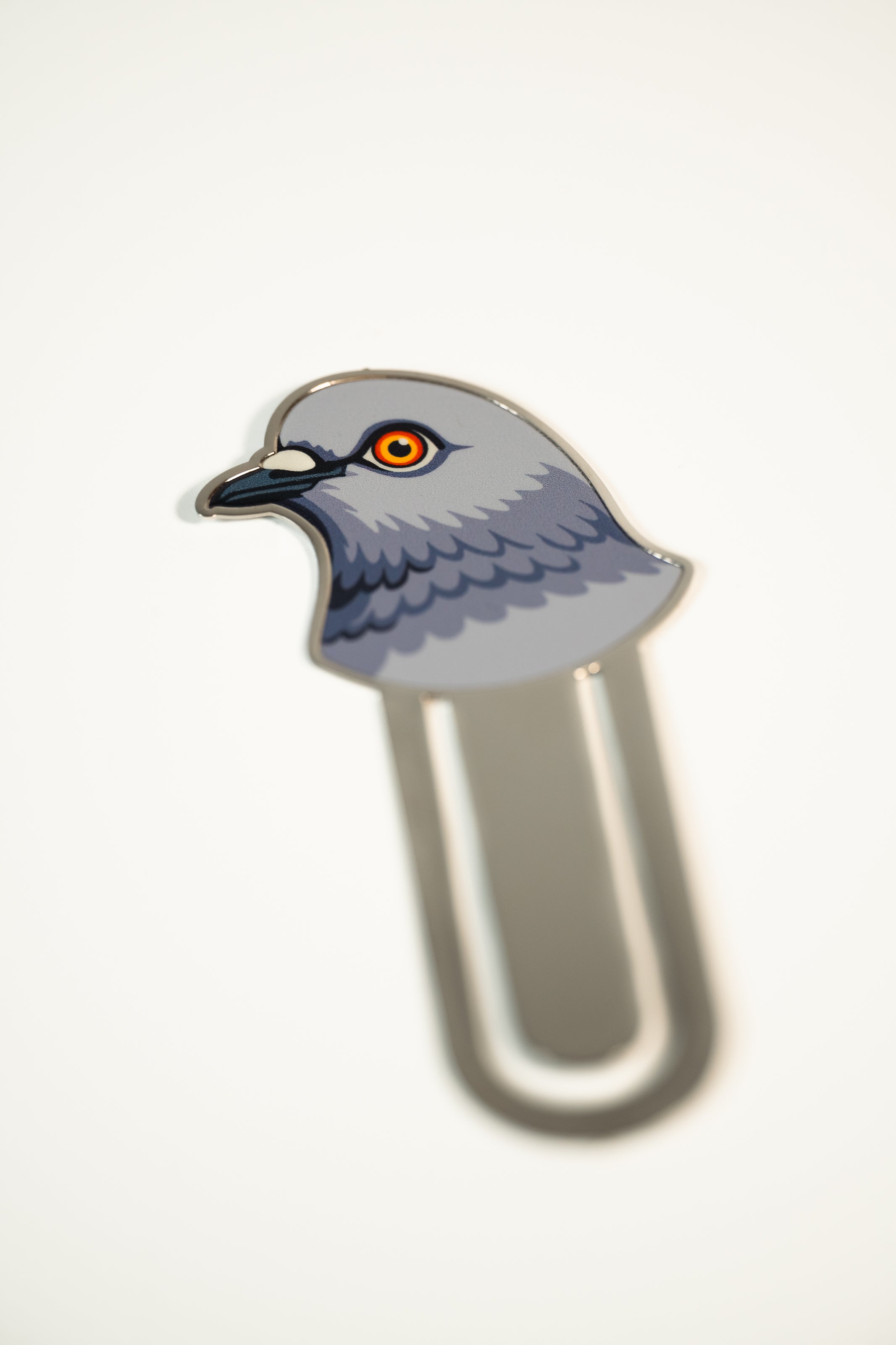 Metal bookmark featuring a pigeon head.