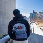Man wearing the Dinosaur Hoodie, standing on the High Line looking south.