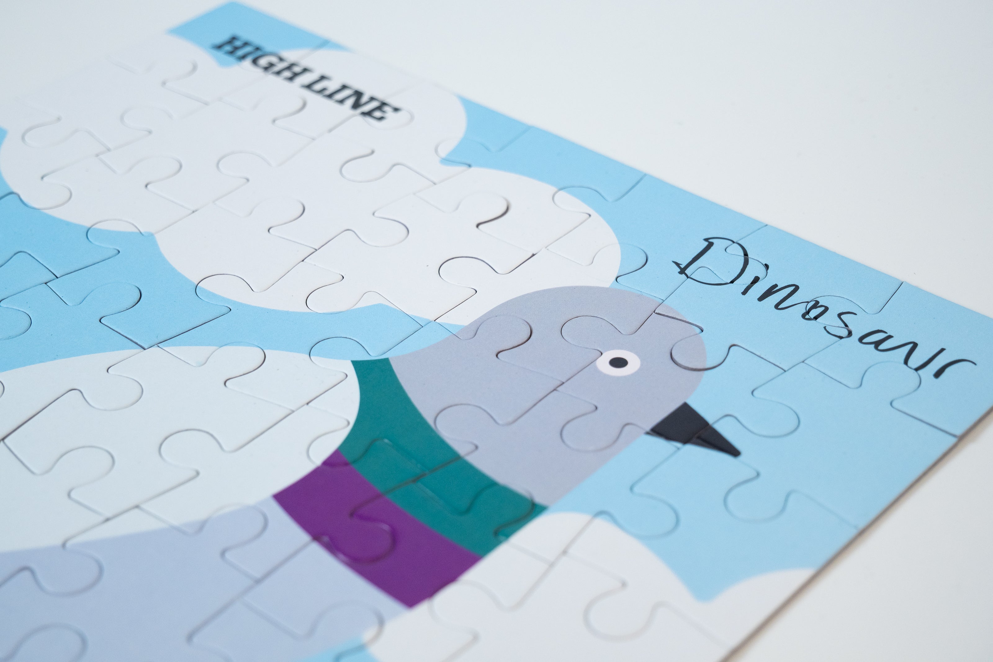 Portion of the completed Dinosaur Kids' Puzzle, showing the pigeon, the High Line logo, and "Dinosaur" in the artist's handwriting.