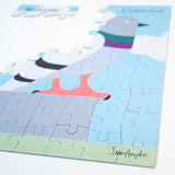 Partially completed Dinosaur Kids' Puzzle, showing the pigeon and the artist's signature in focus.