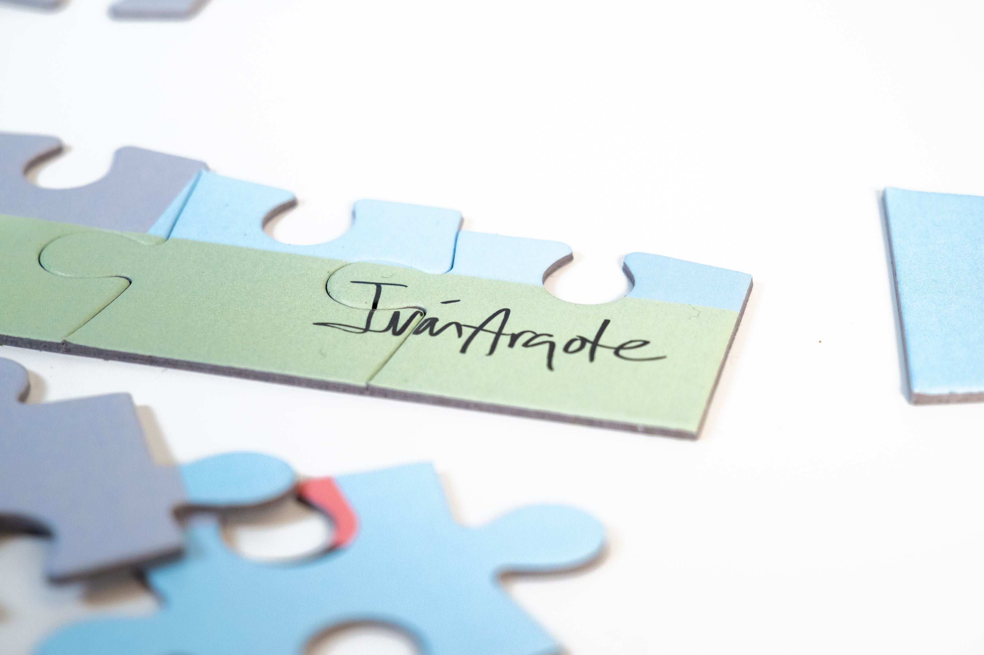 Puzzle pieces with Iván Argote's signature pieced together.