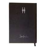 Back cover of black Dinosaur Notebook, featuring the High Line icon and Dinosaur artist Iván Argote's signature.