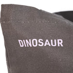 Closeup of "Dinosaur" printed in lavender against the black tote.