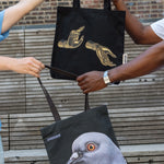The Light That Shines Through the Universe Tote and Dinosaur Tote being passed between two people.