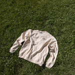 High Line Crewneck lying on the lawn on the High Line at 23rd street.