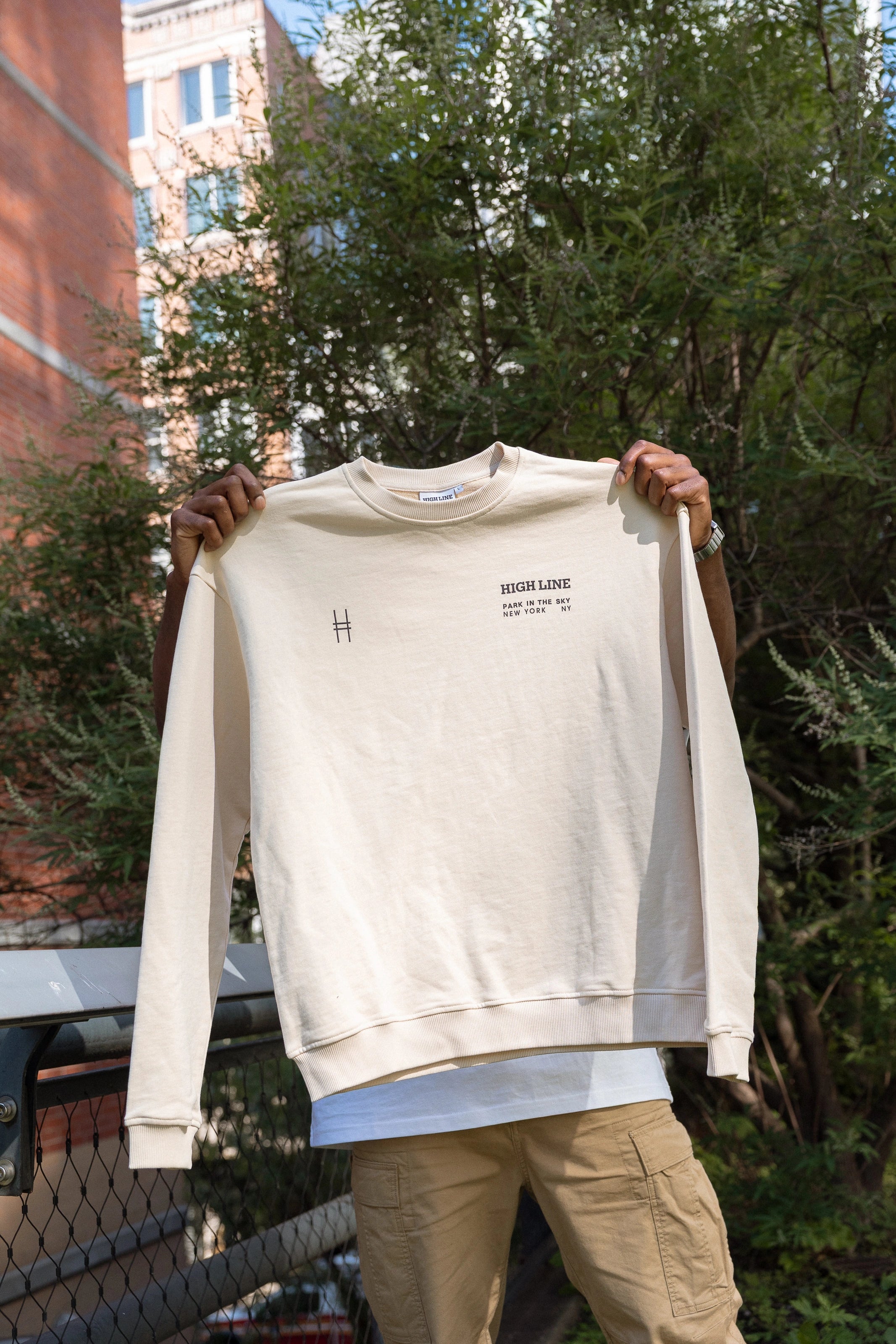 Man holding up High Line Crewneck.