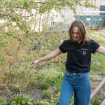 Woman wears the High Line Embroidered black Pocket Tee on the High Line.
