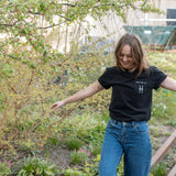 Woman wears the High Line Embroidered black Pocket Tee on the High Line.