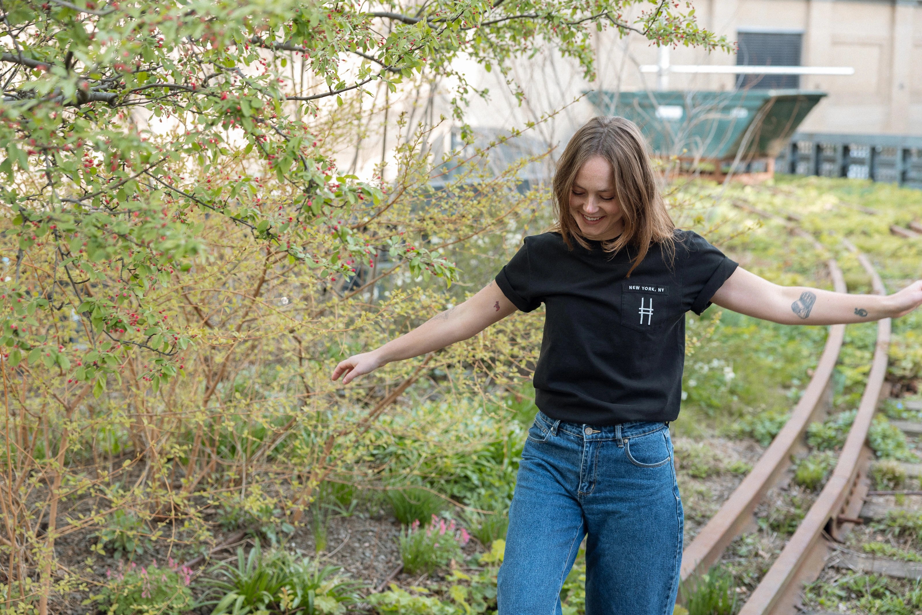 Woman wears the High Line Embroidered black Pocket Tee on the High Line.