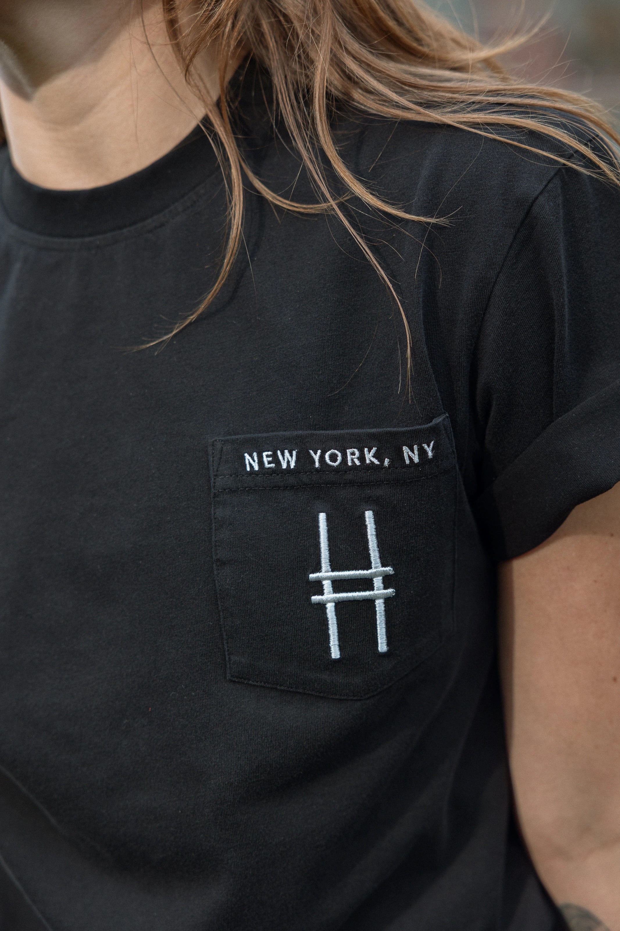 Woman wears the High Line Embroidered black Pocket Tee on the High Line.