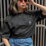 Woman wearing High Line Icon Embroidered Pocket Tee and adjusting her sunglasses.