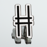 High Line Icon Enamel Pin—the High Line railroad track "H" logomark/icon in black set against white enamel—shown on a mirrored surface.