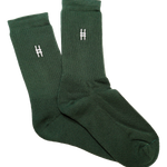 High Line Socks in Ivy. Dark green crew socks with white intarsia High Line icon on each side of each sock.