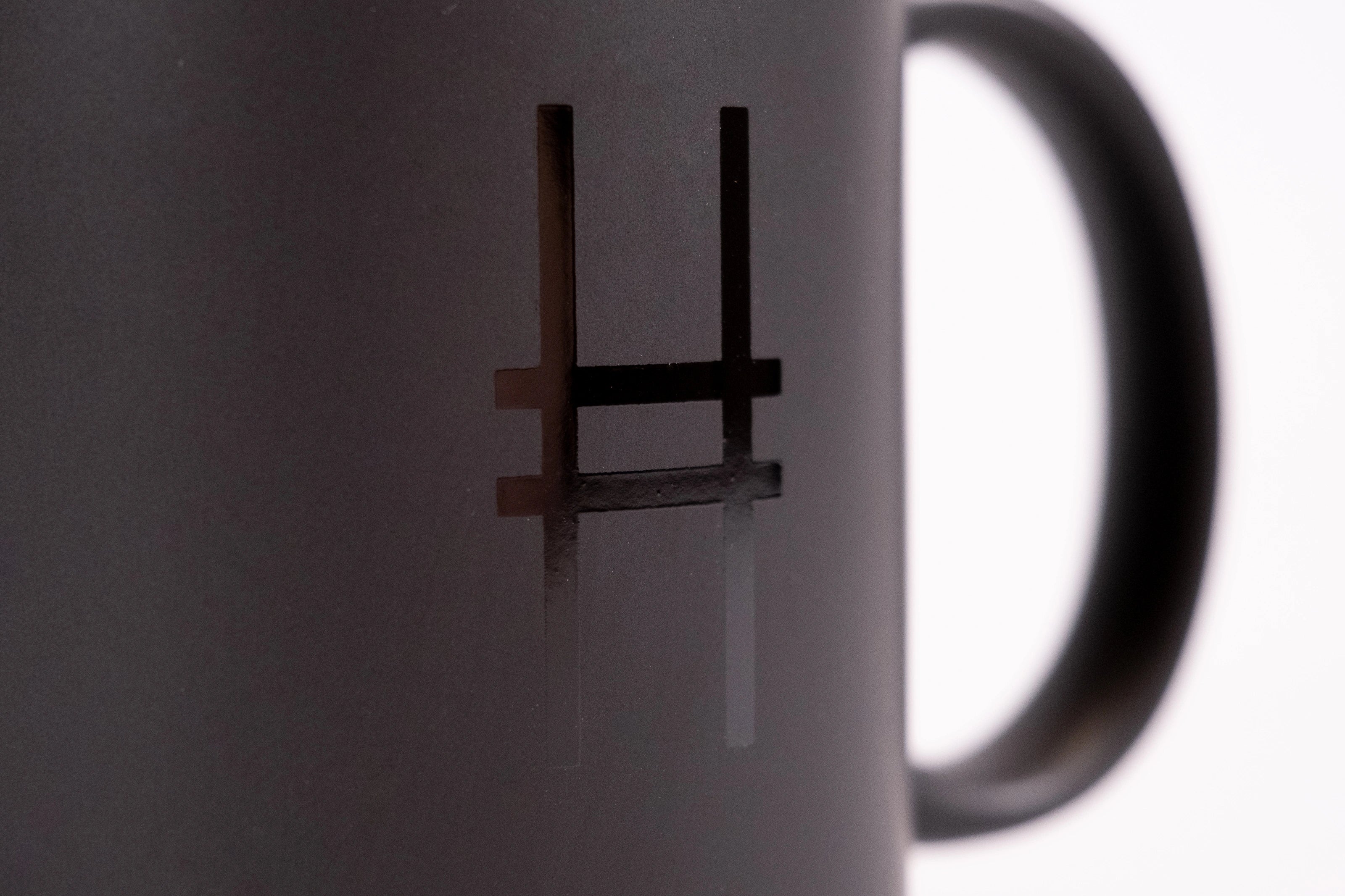 Detailed shot of High Line Mug in Black, featuring the High Line icon in gloss against black matte ceramic.