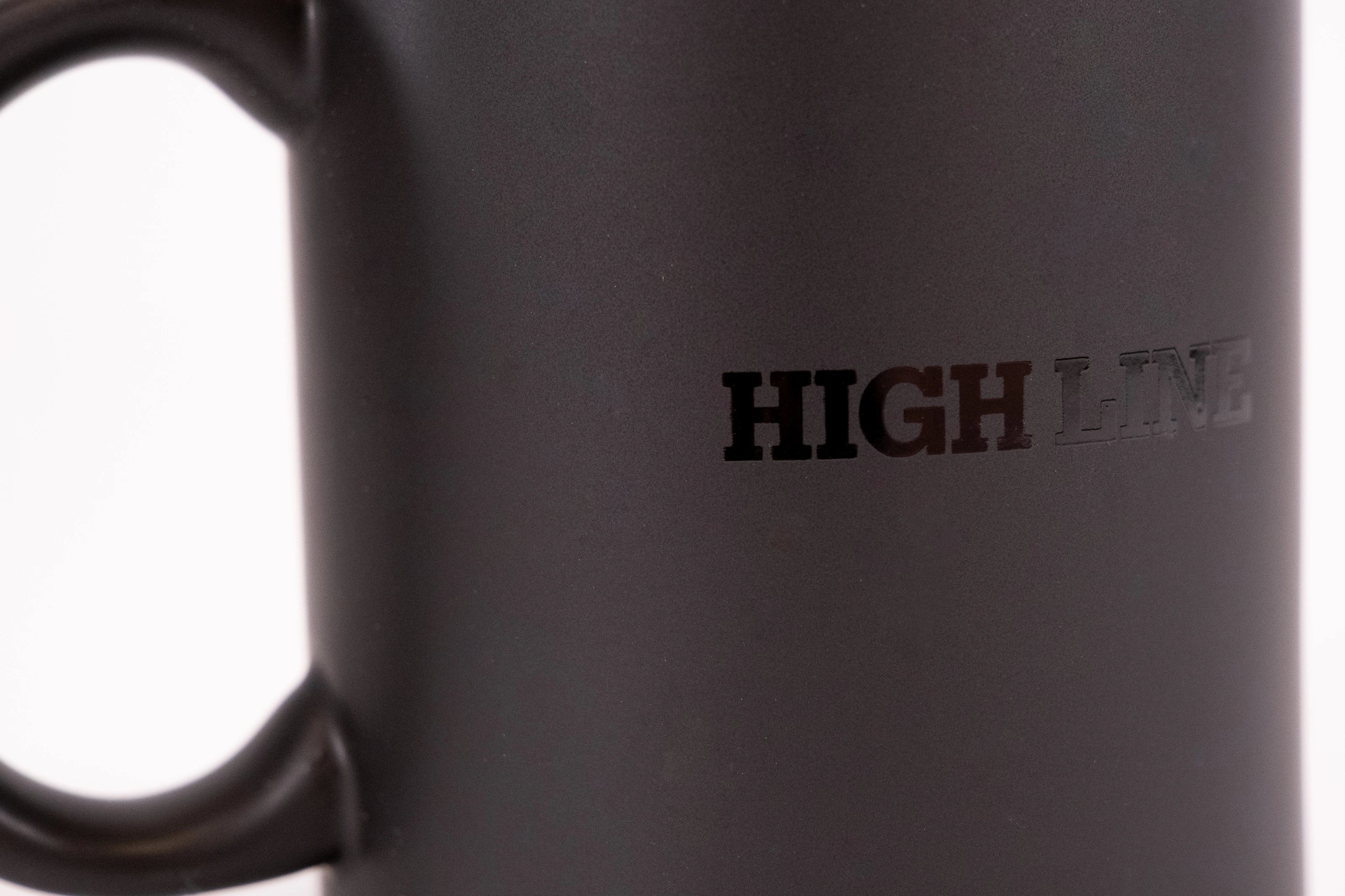 Detailed shot of the High Line Mug in Black, featuring the High Line wordmark in gloss against black matte ceramic.
