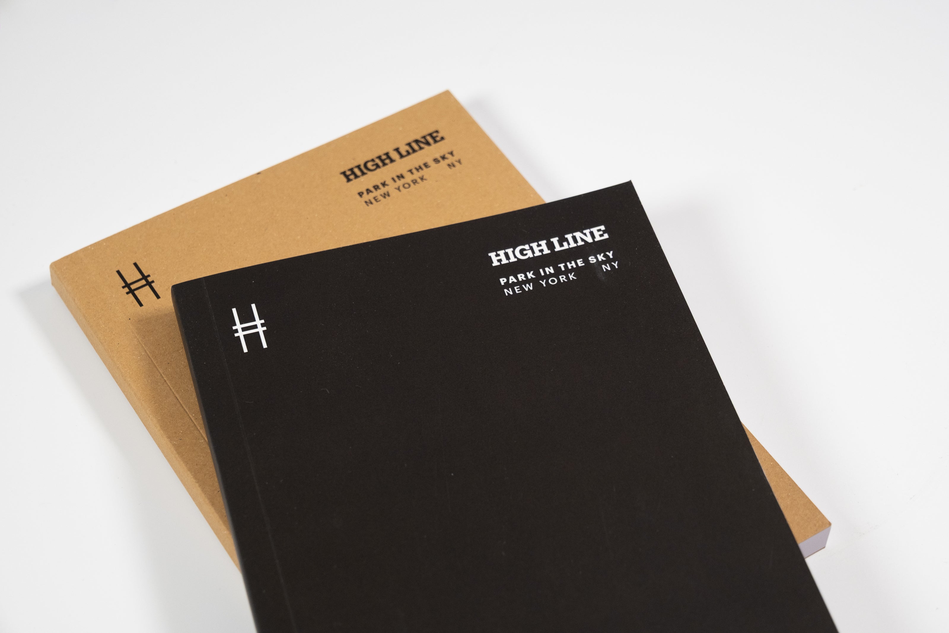 Two notebooks, one black and one kraft, both with 'High Line' branding on a white background.