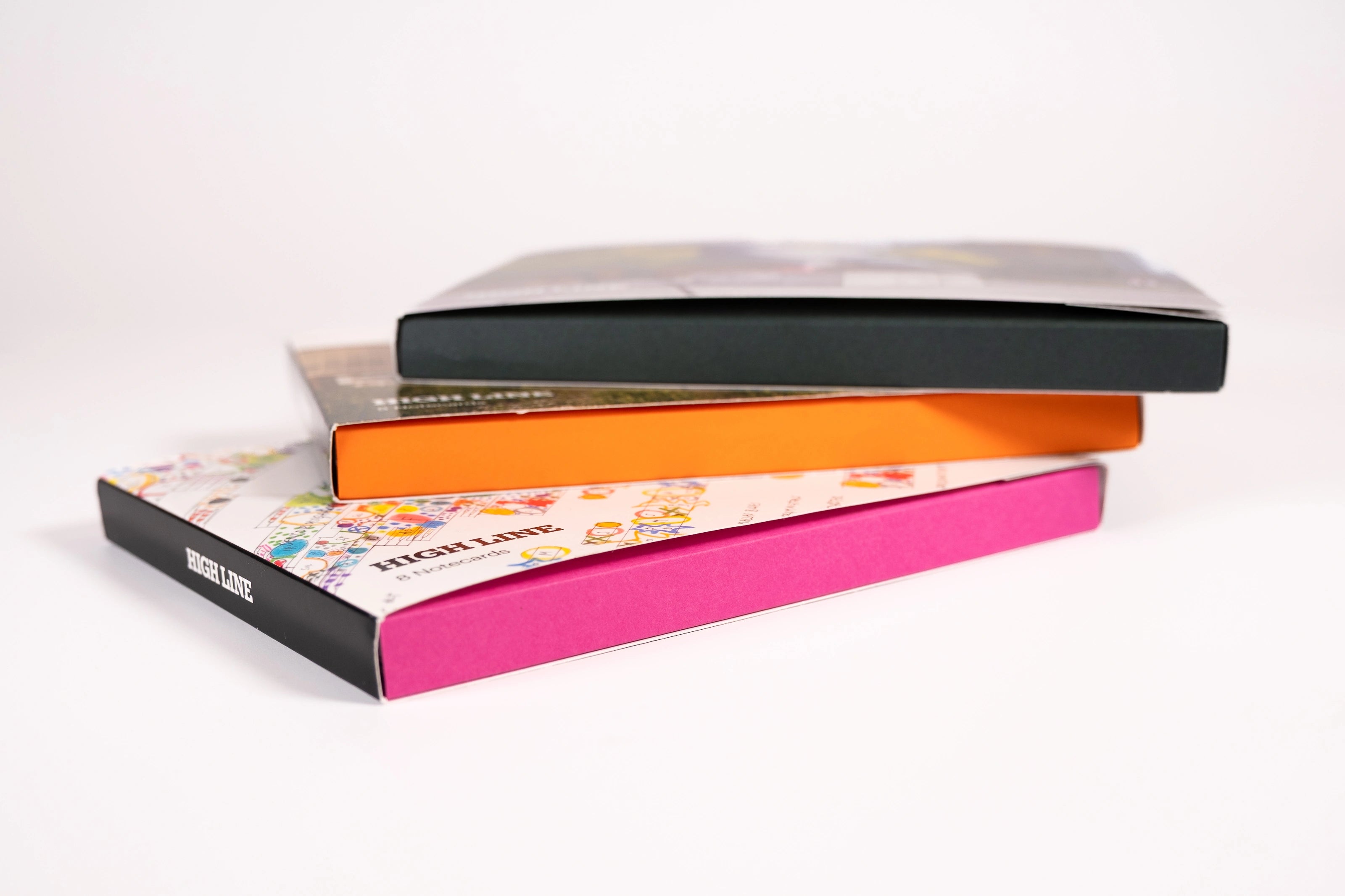Three notecard sets, each with a different color box side, stacked on top of each other. 