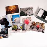 Each of the eight notecards in the HIgh Line Plinth set—each featuring a different photo, with two photos of each of the first four Plinth Commissions—scattered, next to the open box with envelopes still in the "High Line" band.