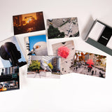 Each of the eight notecards in the HIgh Line Plinth set—each featuring a different photo, with two photos of each of the first four Plinth Commissions—scattered, next to the open box with envelopes still in the "High Line" band.