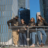 Four people, each wearing The Light That Shines... Hoodie stand on the steps on the northern end of the High Line.