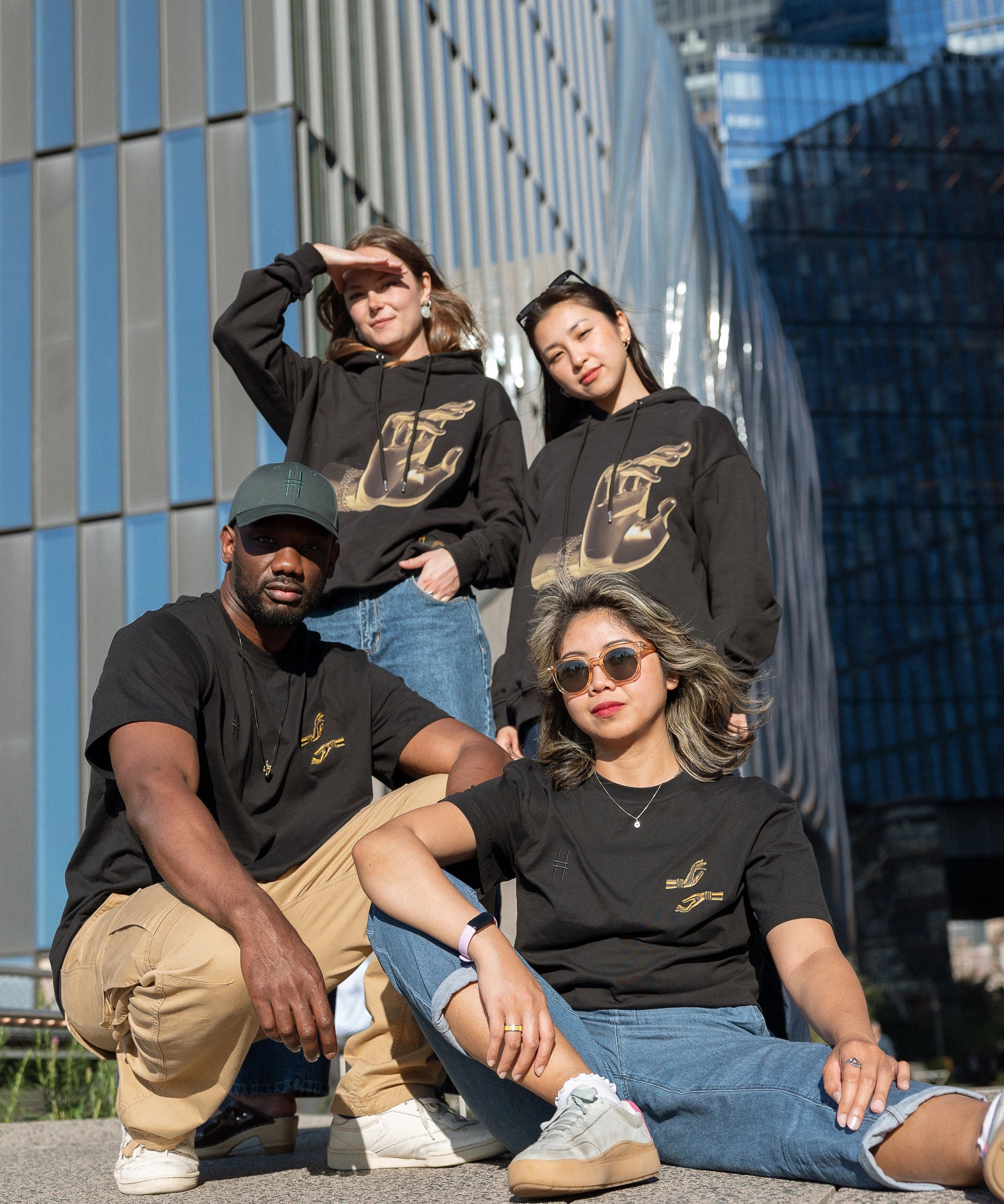 Four people, each wearing either The Light That Shines... Hoodie or Tee, on the northern end of the High Line.