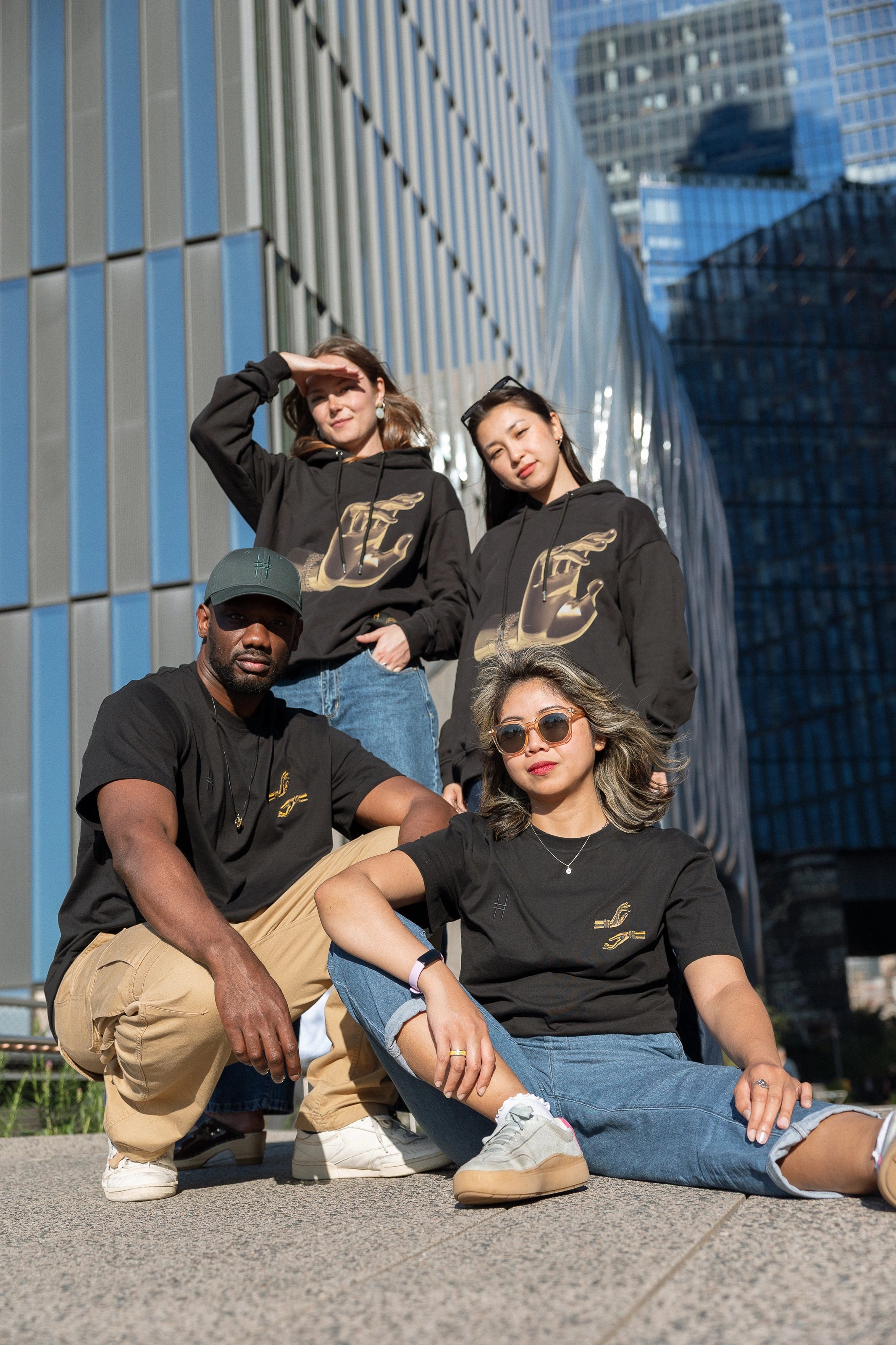 Four people, each wearing either The Light That Shines... Hoodie or Tee, on the northern end of the High Line.