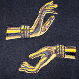 Closeup on the embroidered hands, one in Abhaya mudra, one in Varada mudra.