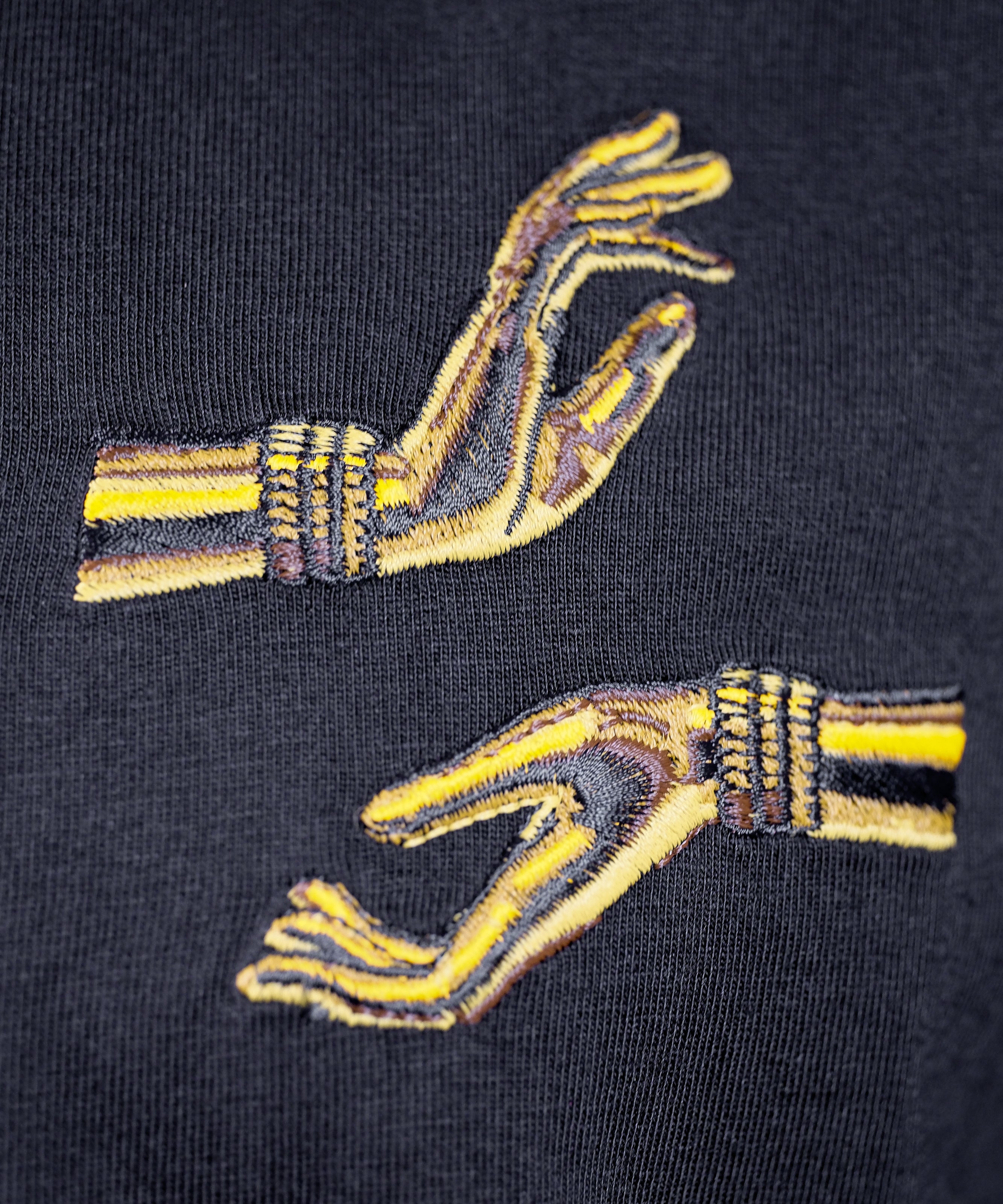 Closeup on the embroidered hands, one in Abhaya mudra, one in Varada mudra.