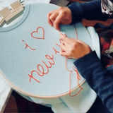 One of Lingua Franca's artisans, embroidering "i <3 new york" on one of their cashmere sweaters.