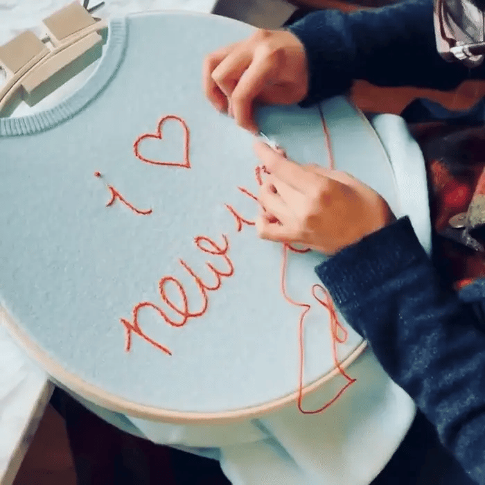 One of Lingua Franca's artisans, embroidering "i <3 new york" on one of their cashmere sweaters.
