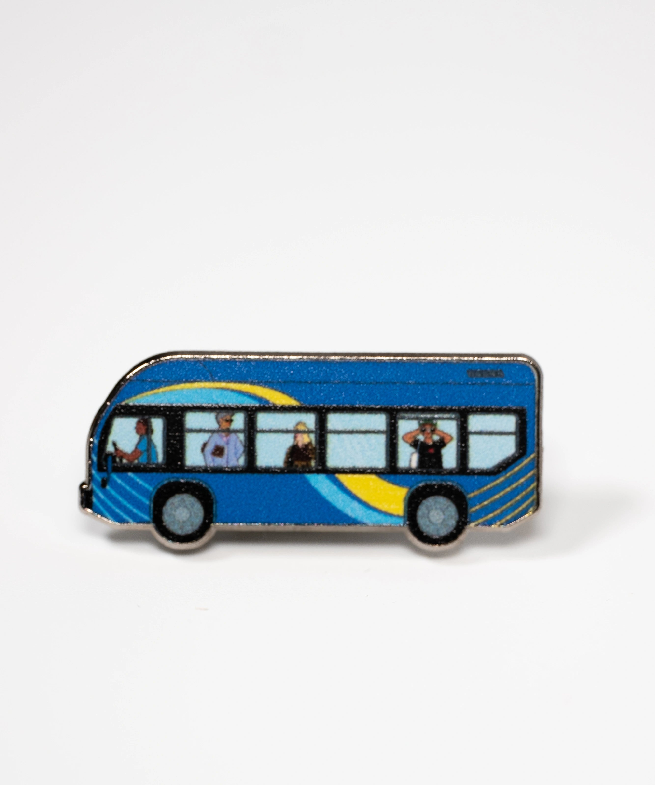 The MTA Bus enamel pin—MTA Bus with driver and passengers, including the sightseer, illustrated by Jiaqi Wang.