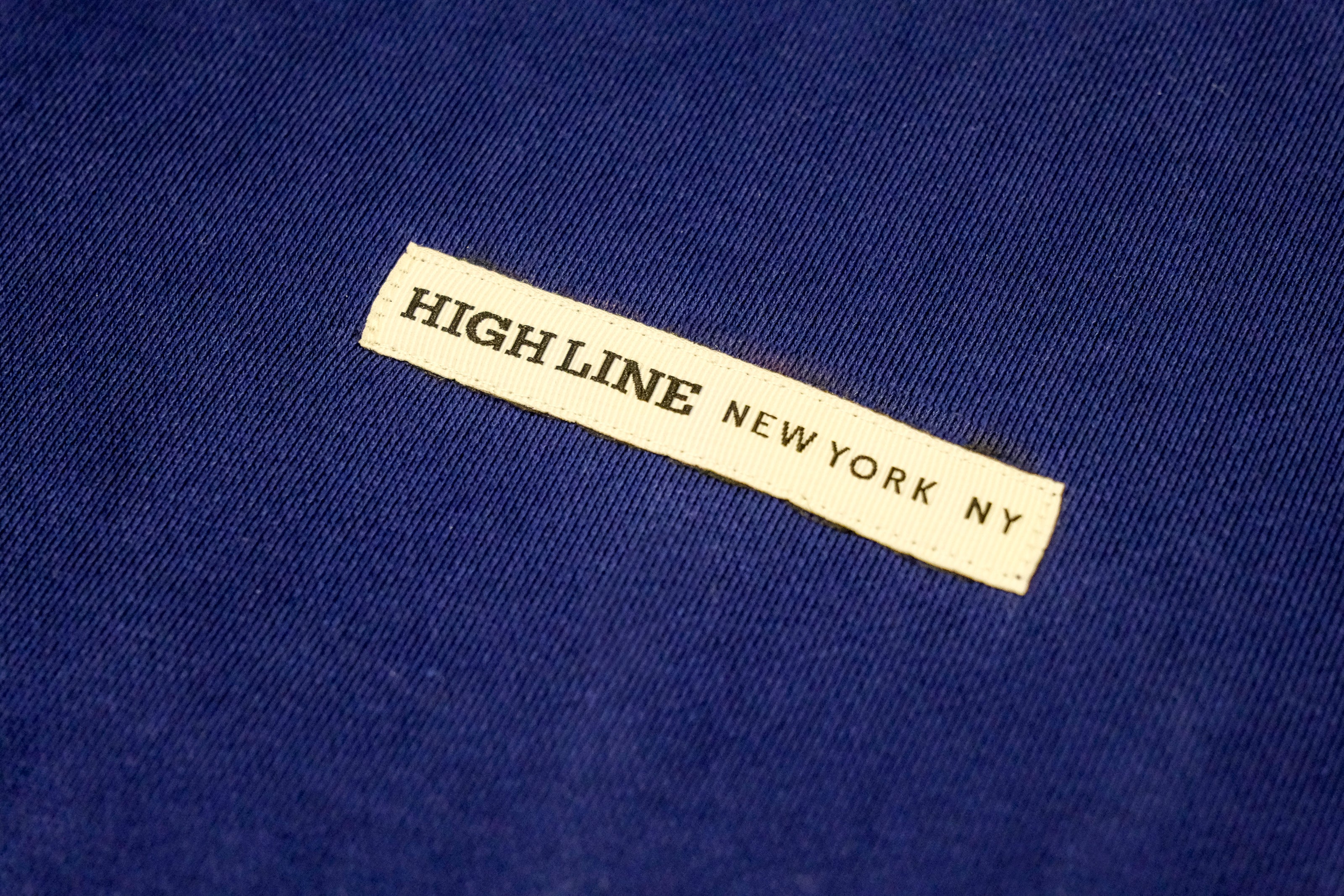 Closeup on High Line New York NY ribbon detail on the front of the Park in the Sky Crewneck Sweatshirt in navy.
