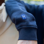 Closeup on High Line icon tag detail on the right sleeve of the Park in the Sky Crewneck Sweatshirt in navy.