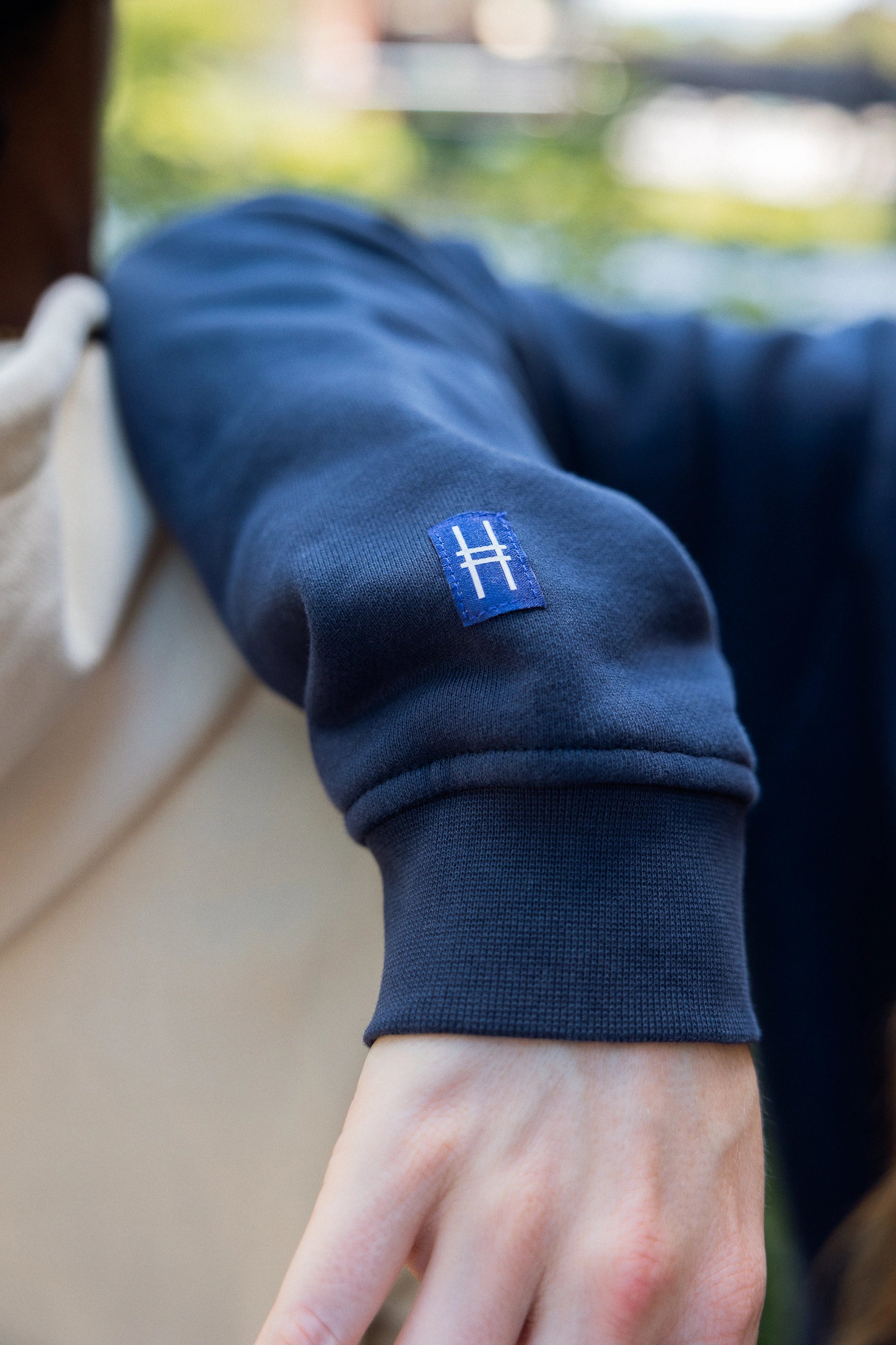 Closeup on High Line icon tag detail on the right sleeve of the Park in the Sky Crewneck Sweatshirt in navy.